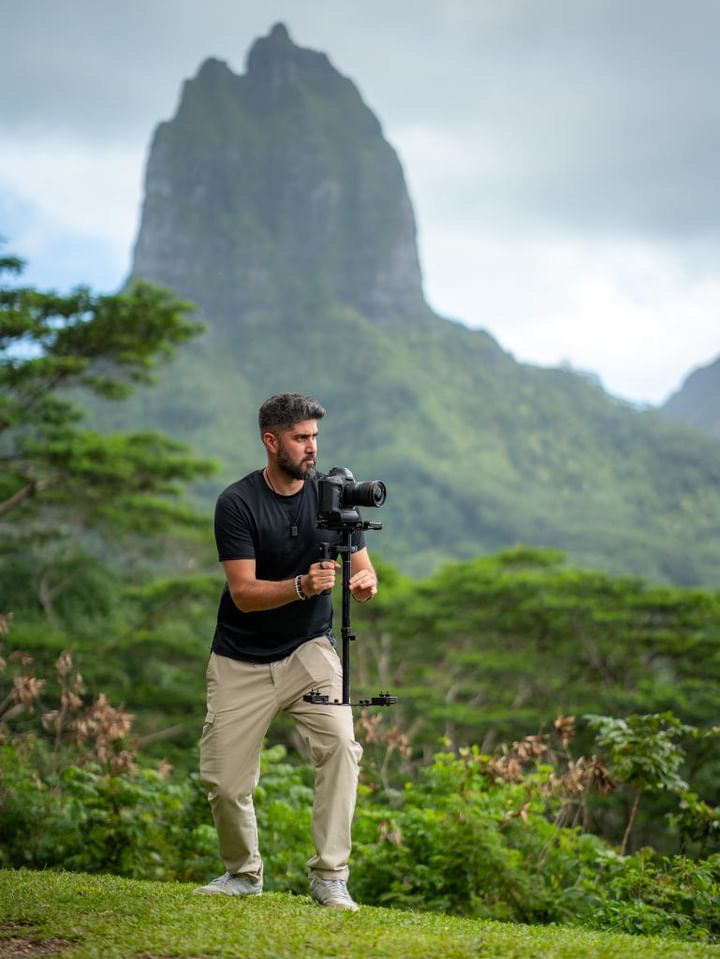 Alex Black filming an adventure in a tropical mountain landscape